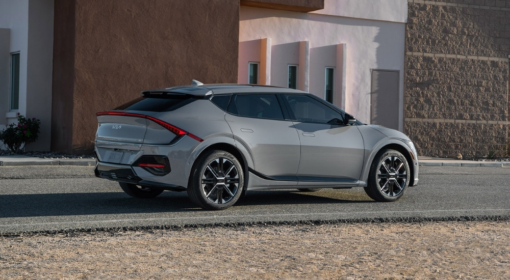 Side view of a grey 2025 Kia EV6 GT-Line parked in front of a brick building.