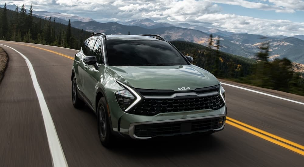 A green 2025 Kia Sportage is shown from the front at an angle after leaving a Kia Dealer.