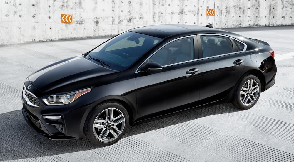 A black 2021 Kia Forte is shown from the side.