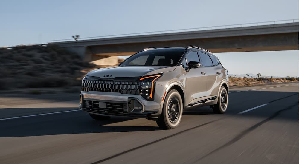 A gray 2026 Kia Sportage for Sale in Glendale driving down a highway
