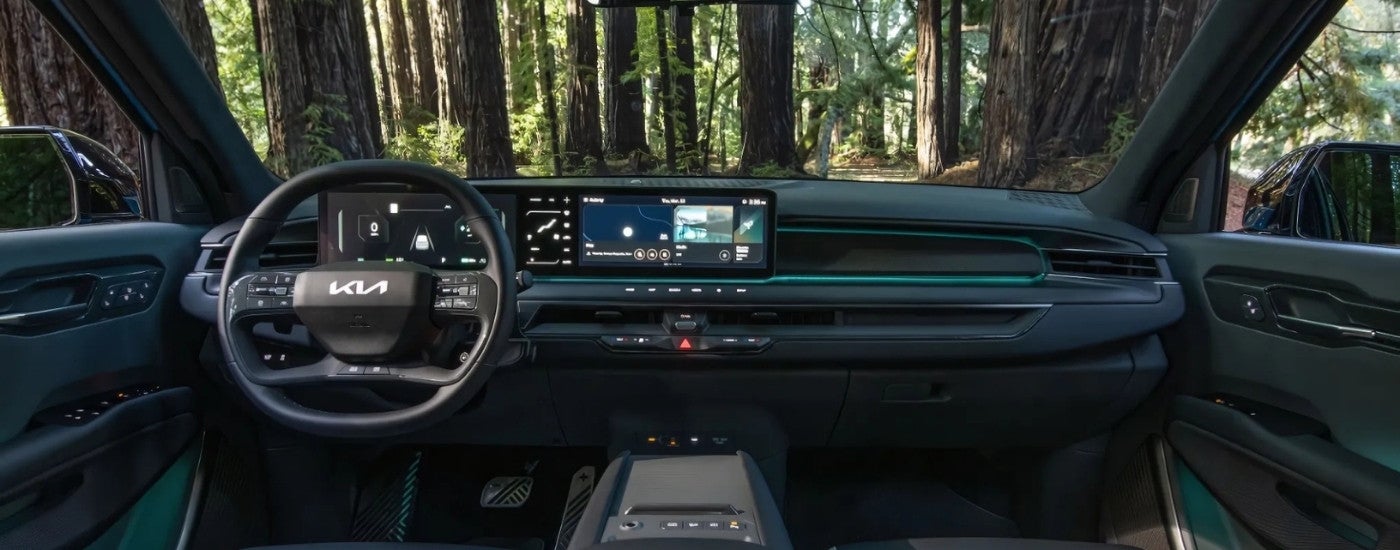 Green ambient lighting in the cabin of a 2024 Kia EV9 parked in the woods.