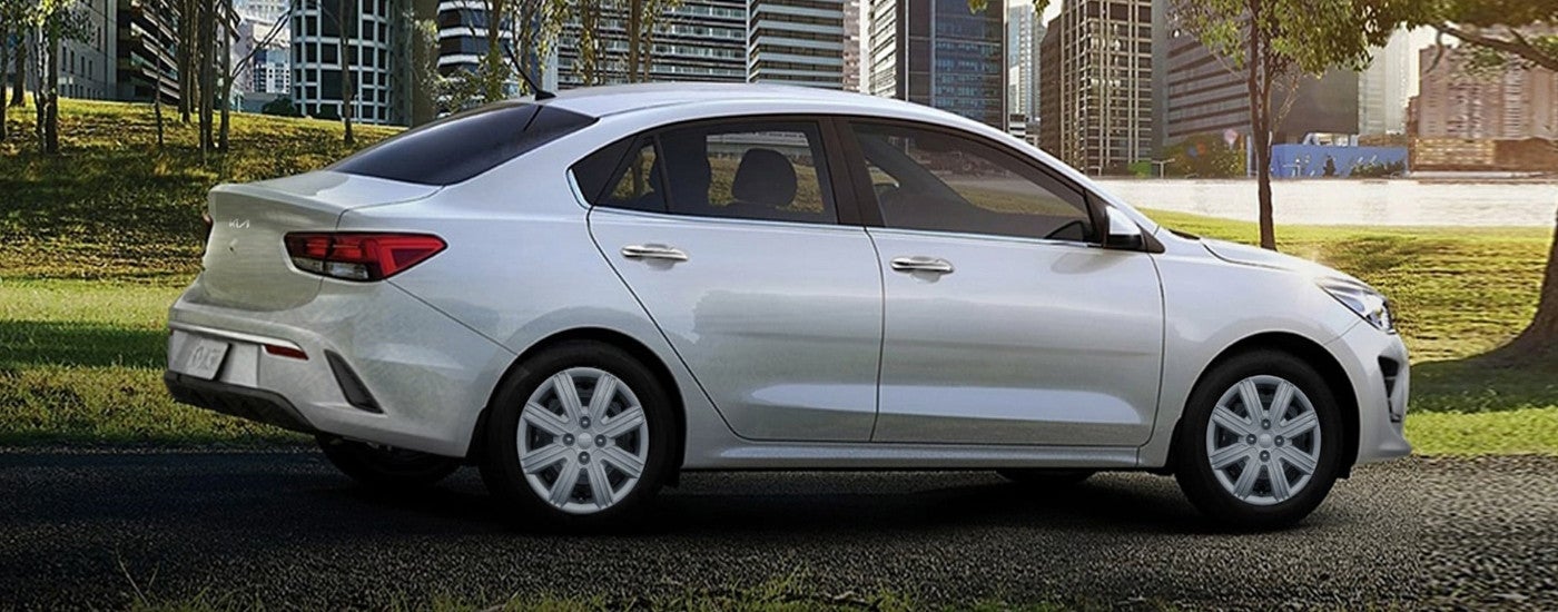 A silver 2023 Kia Rio parked on a path.