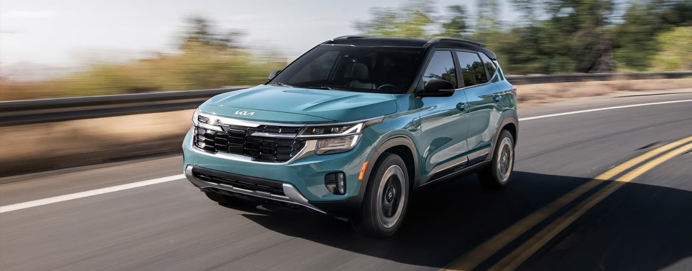 Blue 2026 Kia Seltos for sale driving on a highway