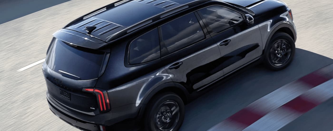 A black 2025 Kia Telluride driving on a track.