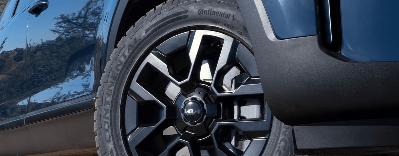 A close up of the tire and rim on a blue 2025 Kia Telluride X-Pro for sale.