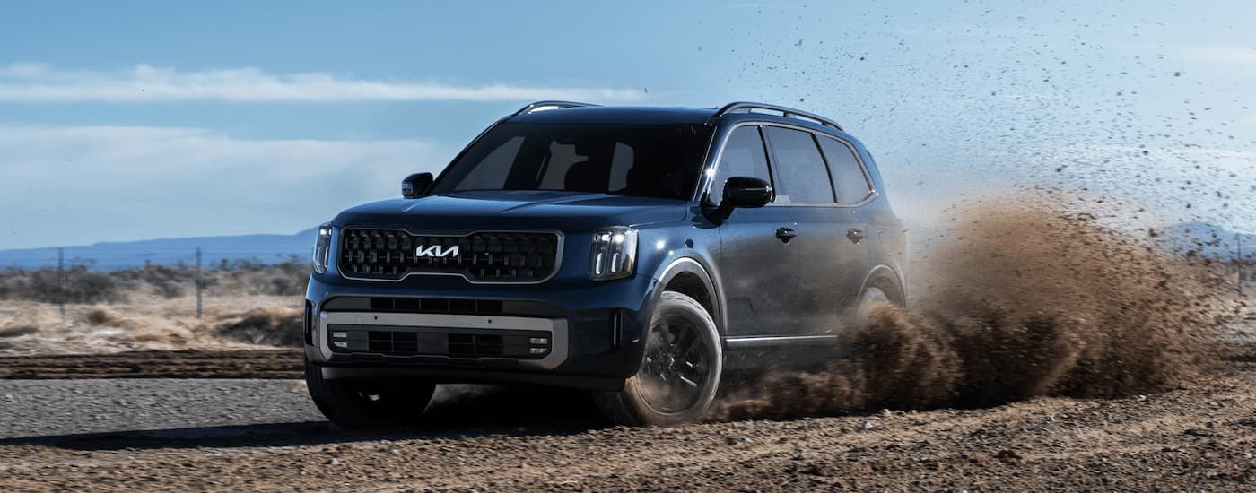 A blue 2023 Kia Telluride off-roading.