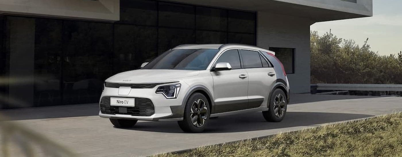 A white 2023 Kia Niro Ev parked after visiting a Kia dealer near Shorewood.