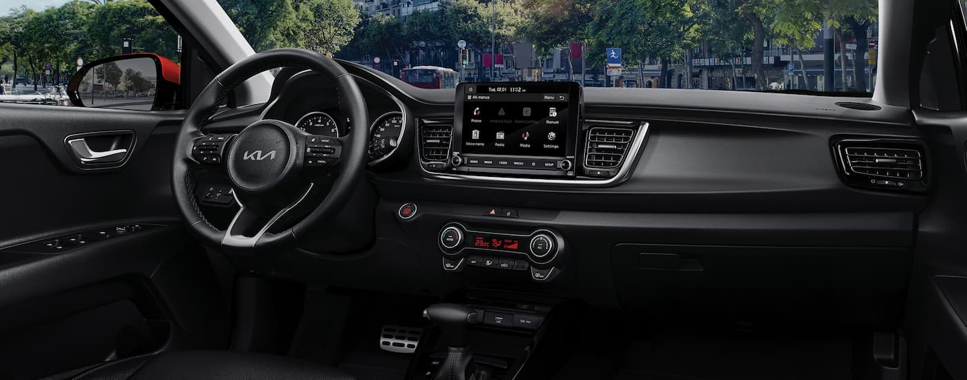 The black dashboard and center console in a 2023 Kia Rio.